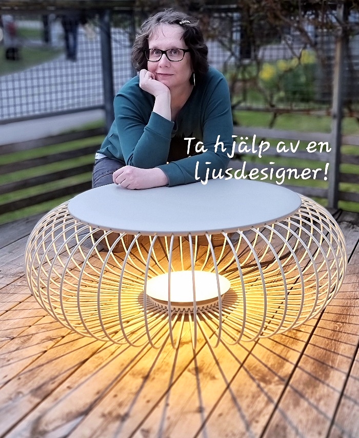 person som lutar sig över en stora lampa. Personen arbetar som ljusdesigner